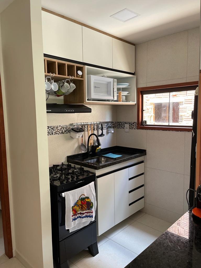 Cozinha equipada com fogão, micro-ondas e utensílios