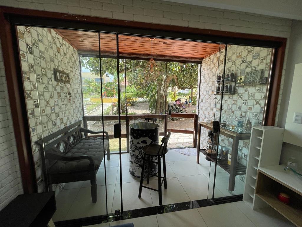 Varanda com fechamento em vidro e vista para o jardim